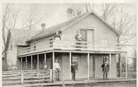 two-story colonial house with 5 people standing on the porches