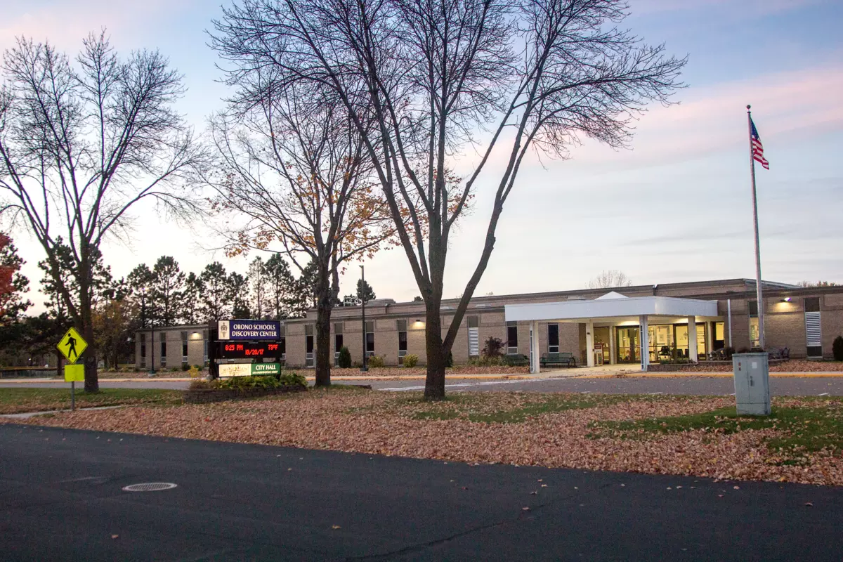 grey building with bare trees in front