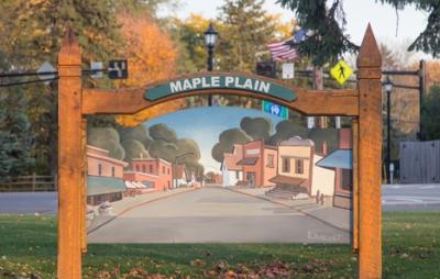 wooden sign with a watercolor painting of the town