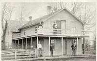 two-story colonial house with 5 people standing on the porches