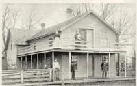 two-story colonial house with 5 people standing on the porches