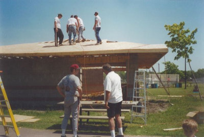 4 workers on the roof of a house and 2 on the ground